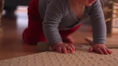 Oyun hasırının üzerinde emekleyen bebek, güvenli ev ortamında hareketin, keşfin ve merakın gelişim kilometre taşı