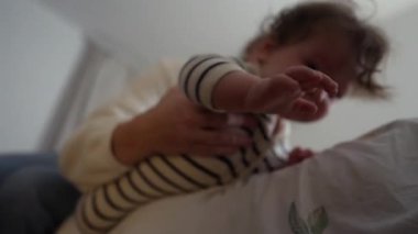 Anne kucağında bebekle yatakta yatarken, şefkatli ebeveyn anlarında bakım, dinlenme ve aile bağlarını besliyor.