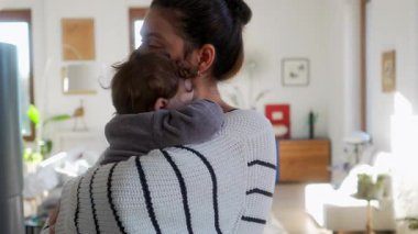 Anne bebeği nazikçe kucağında tutarken oturma odasında, evde sevgi ve şefkat gösteriyordu.