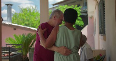 Yaşlı çift açık hava aile toplantısı sırasında dans ediyor ve gülüyor. Keyifli ve keyifli bir atmosferde neşeli bir anın tadını çıkarıyorlar.