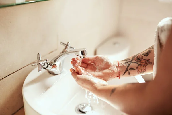 Good habits good health. a woman washing her hands at the bathroom sink