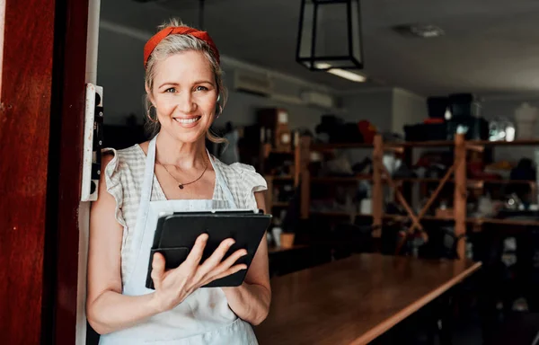 stock image A designers job never ends. Cropped portrait of an attractive mature woman standing alone and using a tablet in her pottery workshop