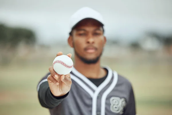 Baseball in hand, baseball player and athlete on field training for sports competition. Young black fitness man, health motivation and softball pitcher catch at stadium with bokeh background outdoors.