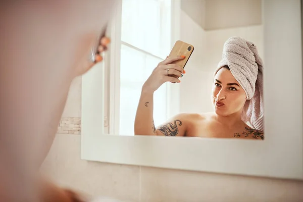 Be you, only better. a young woman taking a selfie while going through her morning beauty routine