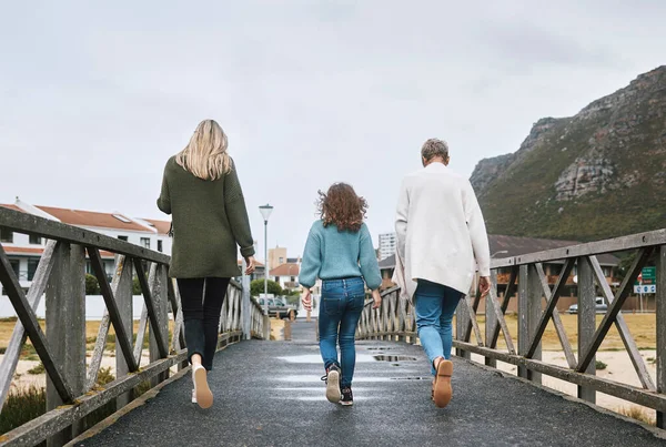Family, walking and bridge in nature by mountain together on holiday, vacation and relax. Group, people and walk for bonding, time and love with kid, mother and grandmother on travel to Norway.