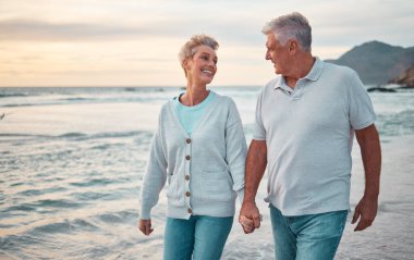 Kumsal, el ele tutuşmak ve gün batımında dışarıda sağlık, emeklilik tatili ve açık hava randevusu için gökyüzü taklidi yapan yaşlı çift. Mutlu yaşlı insanlar, ya da deniz ya da okyanus suyunda yürüyen yaşlı bir adam ve yaşlı kadın..