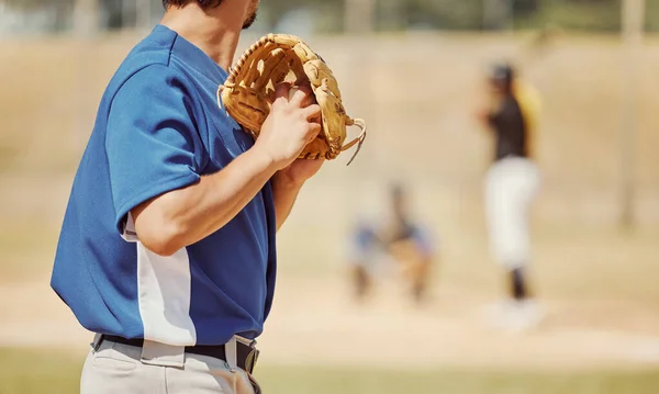 Baseball, sports and pitcher with a ball and glove to throw or pitch at a match or training. Fitness, softball and man athlete playing a game or practicing pitching with equipment on outdoor field