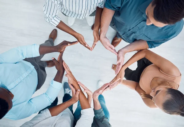 Diversity, hands and business people in support for love, care and community in solidarity at the office. Group hand of employee workers in teamwork, collaboration and unity above in heart shape sign.