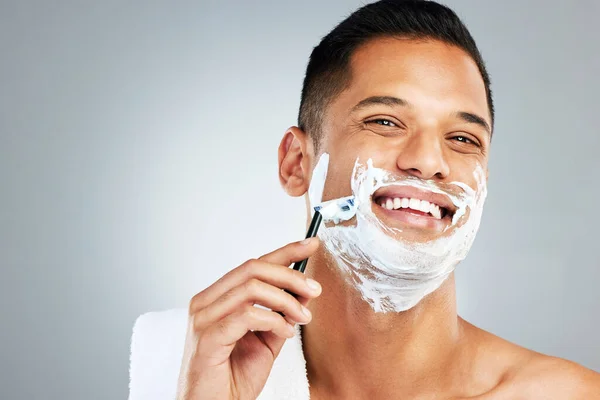 Skincare, facial and man shaving beard or face hair for cleaning cream and razor. Happy latino male shave, handsome and epilation care of skin during morning routine for beauty and hygiene wellness.