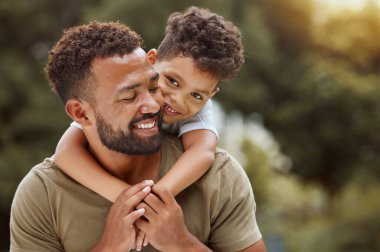 Aile, sevgi ve baba ve oğlu parkta, rahatlayın ve kucaklaşın bu arada kaliteli zaman geçirin, bağ kurun ve doğada eğlenin. Siyah aile, çocuklar ve ebeveynler kucaklaşır, gülümser ve boş zamanların ve ormanda yürümenin tadını çıkarır..