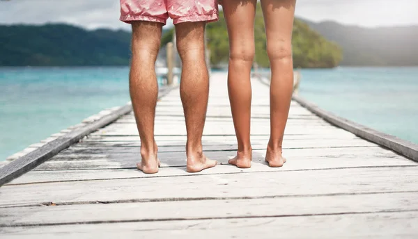 Stand tall and stand proud. Rearview shot of an unrecognizable couple standing on a boardwalk overlooking the ocean during a vacation