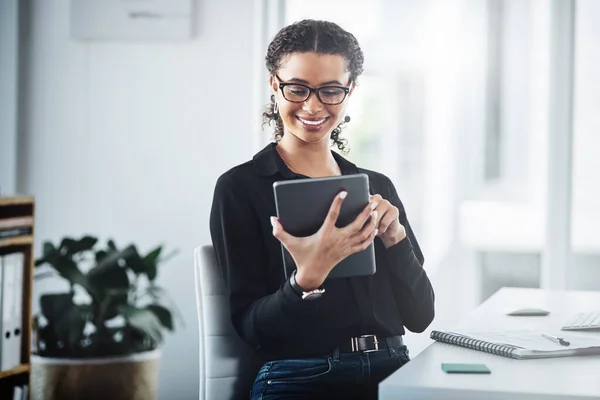 Getting connected to some new opportunities. a young businesswoman using a digital tablet in an office