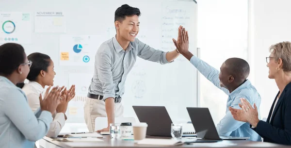 High five, motivation and success with a team in a meeting for planning, strategy and training together. Support, teamwork and partnership with an employee group in celebration in the boardroom.