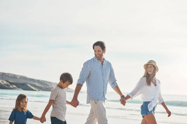 リーダーを追え 2人の子供と幸せなカップルが手を取り合いビーチを歩き — ストック写真