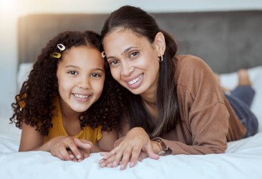 Anne, kız ve mutlu aile sabahı yatak odasındaki yatakta aile sevgisini ve ilgisini hissederek. Bir evde birbirine bağlanmış bir anne ve çocuğun portresi. Mutluluktan gülümseyen bir gülümsemeyle..