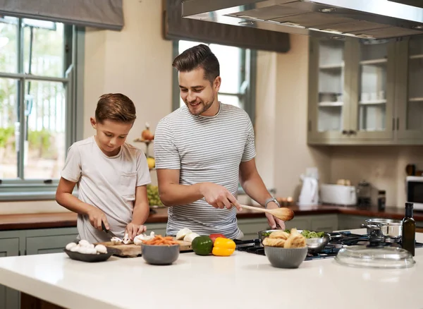你准备好吃这些蘑菇了吗 一个小男孩在厨房帮他父亲做饭 — 图库照片