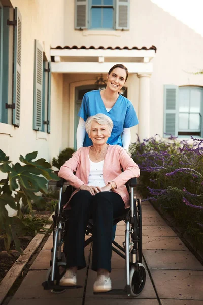 最高のケアを受ける 車椅子の高齢患者がいる外の若い女性看護師は — ストック写真