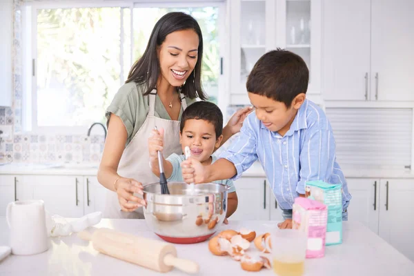 Baking, kids and mom in the home kitchen cooking food with a boy and baby with happiness. Family, mother and happy children smile at a house teaching with ingredients together smiling in family home.