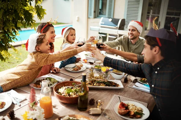 The best gift around the Christmas tree is family. a family making a toast on Christmas day