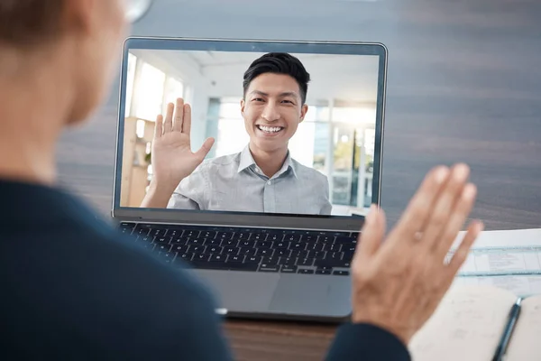 Business people wave in a video call meeting via laptop networking, talking and planning a development project. Smile, communication and Asian employee in a b2b partnership with a corporate manager.