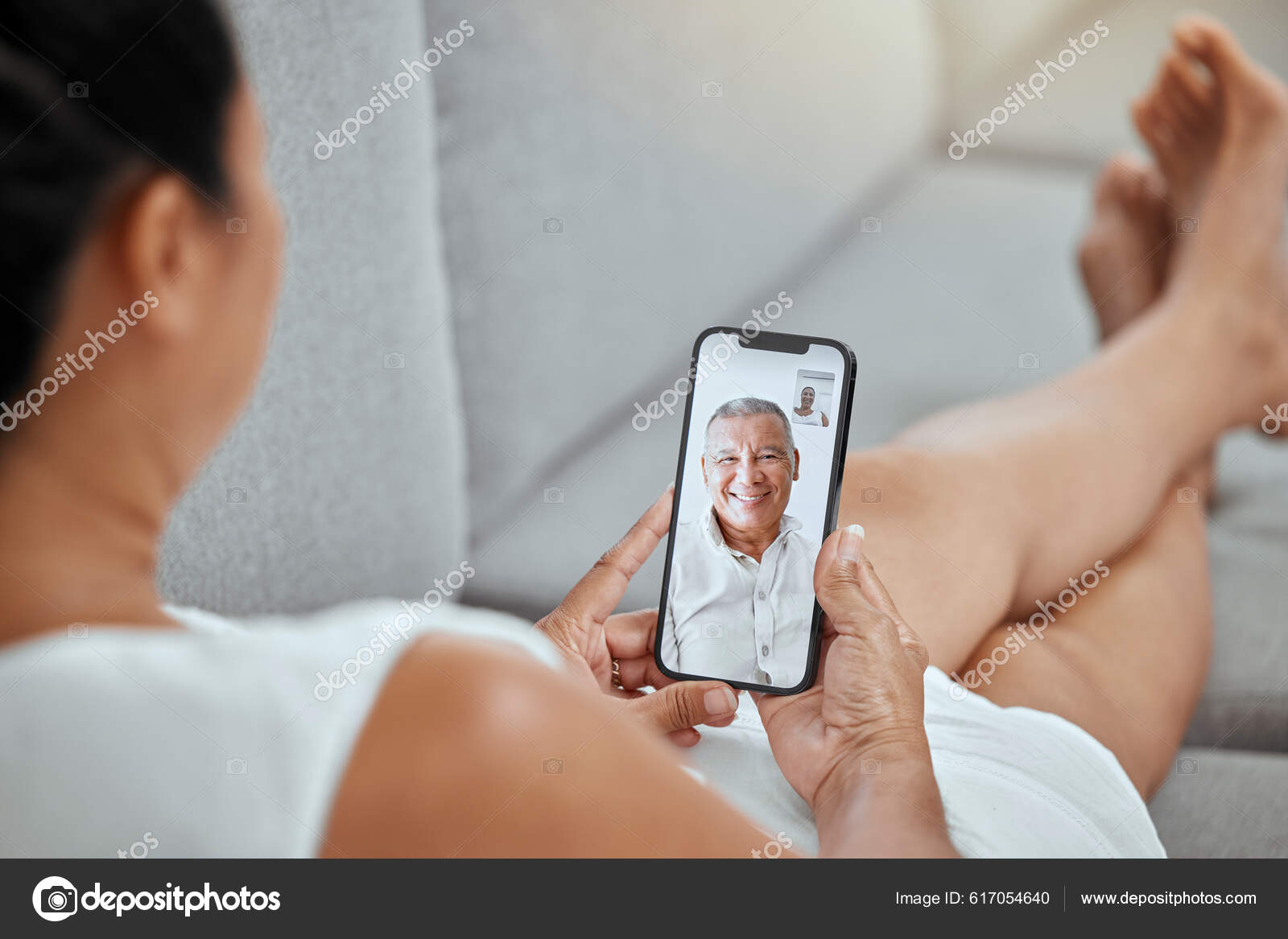 Garota feliz com telefone relaxa no sofá ou no sofá da sala