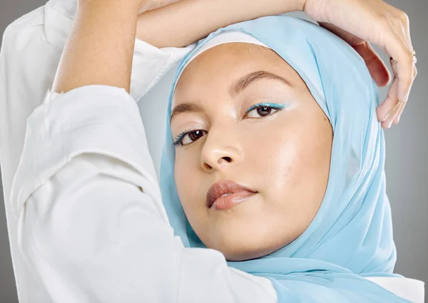 灰色のスタジオの背景にヒジャーブと美容化粧品や化粧品でイスラム教徒 女性と顔 ファッション スタイルやイスラム文化のためのポーズ青いスカーフを身に着けている美しい女性モデルの肖像画 — ストック写真