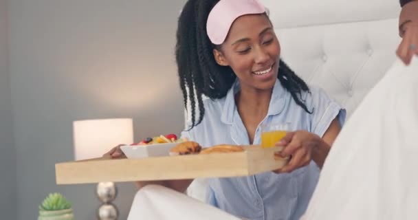 ベッド 黒の人々は 朝の栄養 ウェルネスのための健康的な食品をカップルし 一緒にベッドルームで食べる フードフルーツ クロワッサンとオレンジジュースともに幸せな女性とアフリカの男キス — ストック動画
