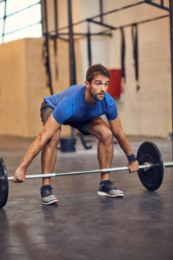 Bir tane daha. Spor salonunda ağırlık kaldıran yakışıklı bir delikanlının uzun pozu.