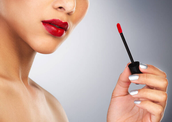 Put on some red lipstick and pull yourself together. an unrecognizable woman applying red lipstick to her lips
