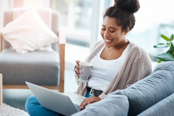 stock image Grabbing coffee and chatting with friends Perfect. an attractive young woman using her laptop to make a video call at home