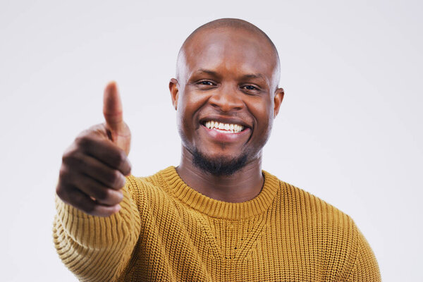 I had no choice but to approve. Studio portrait of a handsome young man giving a thumbs up against a grey background