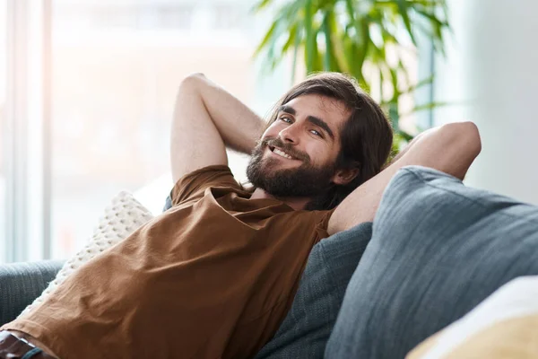 stock image Im happy and at peace with myself. a handsome young man relaxing on a sofa in his living room