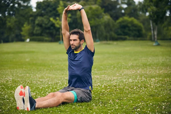 stock image The more you stretch the better youll feel. a sporty man starting his exercise routine with stretching exercises