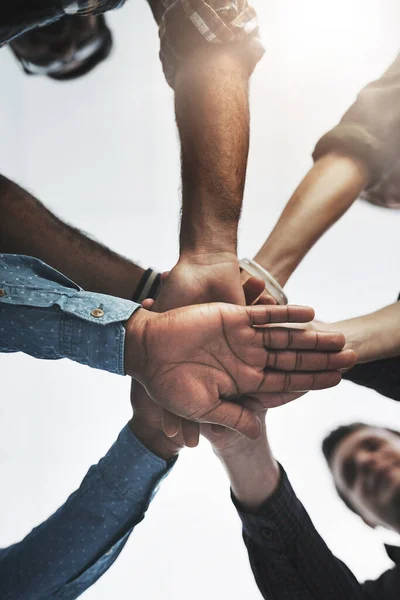 stock image Together we can achieve anything. Low angle shot of a group of businesspeople holding hands together in a modern office