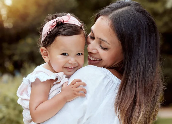 stock image Happy mother with girl baby hug in a park with summer love, smile and care or growth development wellness. Happy latino mom with kid in portrait together nature outdoor for mothers day with happiness.