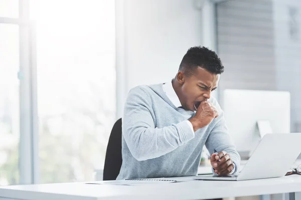 Stock image All the long days at the office will prove fruitful. a young businessman sitting at his office desk yawning and looking tiresome