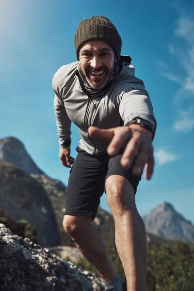 私の手を取り 一緒に旅をさせてください 山の中をハイキングしながら手を伸ばしている中年男性の低角度の肖像画 — ストック写真