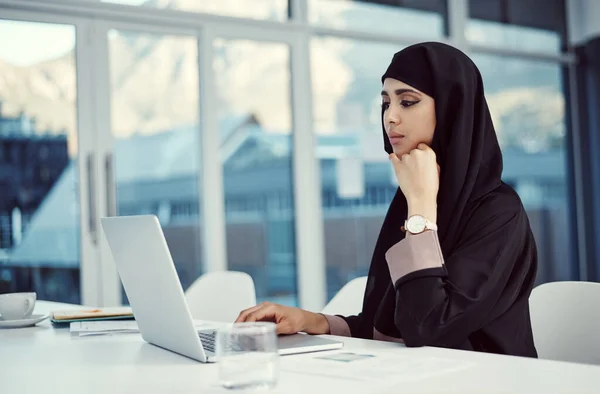 stock image Success is there if you work for it. an attractive young arabic businesswoman working on her laptop in the office