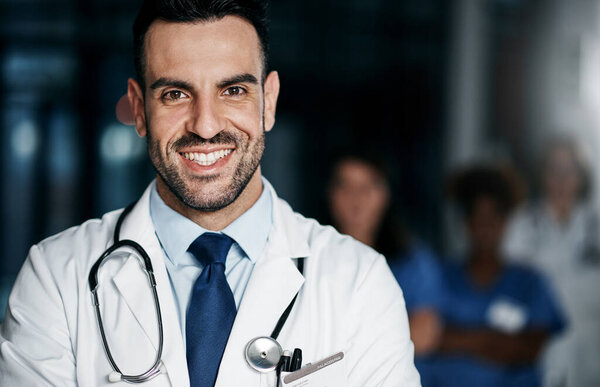 The leading experts in medical health. Portrait of a confident young doctor working in a hospital with his colleagues in the background
