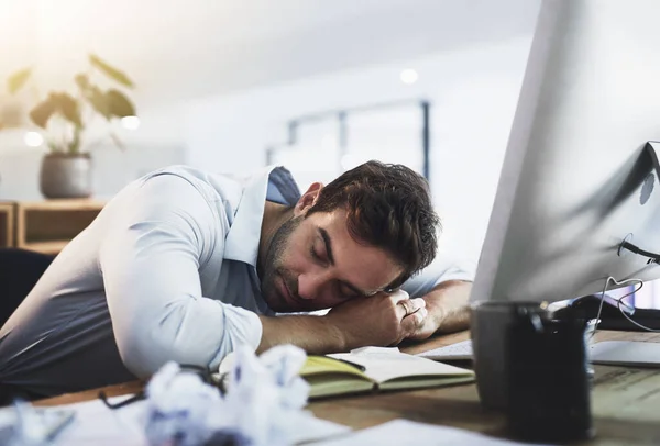 私は2分間目を閉じます オフィスで遅く働いている間に彼の机で寝ている若いビジネスマン — ストック写真