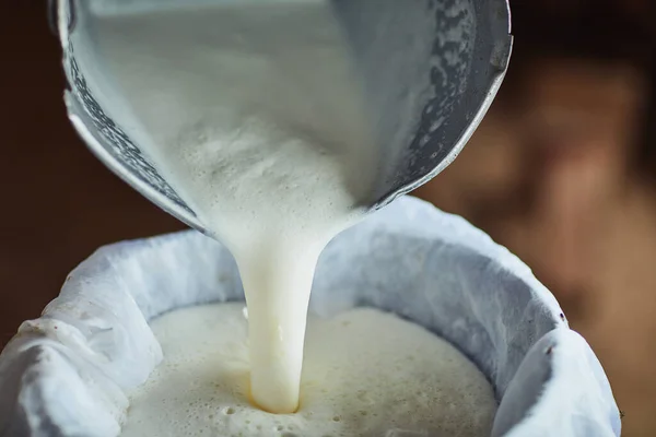 stock image All in a day on the dairy farm. an unrecognizable male farmer pouring unprocessed milk into a container inside a barn