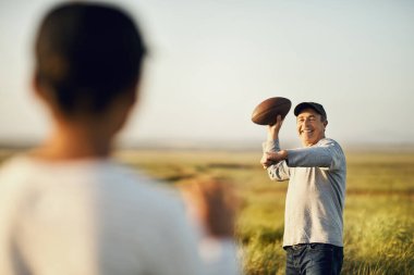 Bu oyunu seviyoruz. Baba oğul açık alanda futbol oynuyorlar.