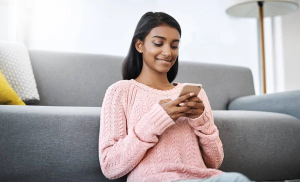 stock image The weekend is always fun with wifi. a young beautiful woman using a cellphone while sitting on the floor in the living room at home