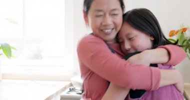 Mutlu, sevgi dolu ve Asyalı bir anne, çocuğunu gülümseyerek kucaklıyor, aile evinde bağ kuruyor ve ona özen gösteriyor. Mutluluk, kaynaşma ve anne, Asya 'da bir evde kızını sevgi, şefkat ve şefkatle kucaklıyor.