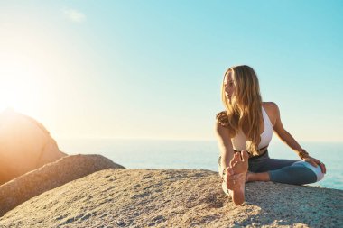 Yoga beni daha iyi biri yapıyor. Sahilde yoga yapan atletik bir genç kadın.