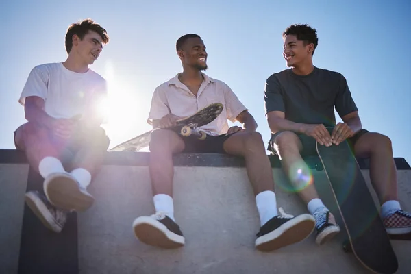 多様性 友人やスケートボードを持つ男性と一緒に街の壁に話しています 幸せな会話 笑いとジェンZスケート友情グループとともにストリートファッションボンディングでスケートパーク屋外 — ストック写真