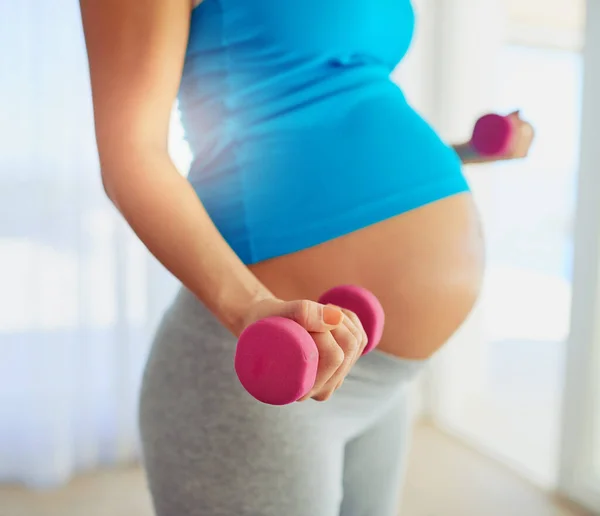 stock image Fit weights on no one. a pregnant woman working out with weights at home