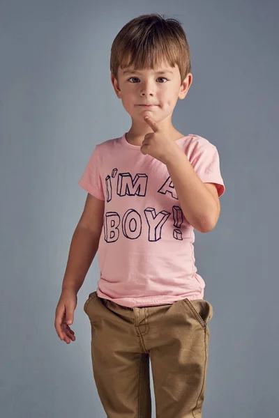 私はこの服を自分で選んだ Tシャツを着た少年のスタジオポートレートグレーの背景にプリントされた少年 — ストック写真