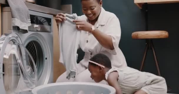 お母さん 子供の笑顔と一緒にきれいな 新鮮な香りの服や高速作業のための洗濯機技術で洗濯を教える 幸せな黒の母 女の子の家事や家庭の雑用を学ぶ — ストック動画