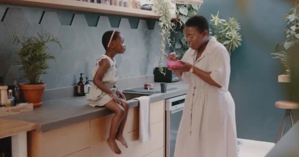 黒の家族 母親と少女の給餌と家庭のキッチンで子供のケアと愛を示すために食べる 空腹の子供と幸せなママは 家族の時間と朝の朝食と一緒に — ストック動画